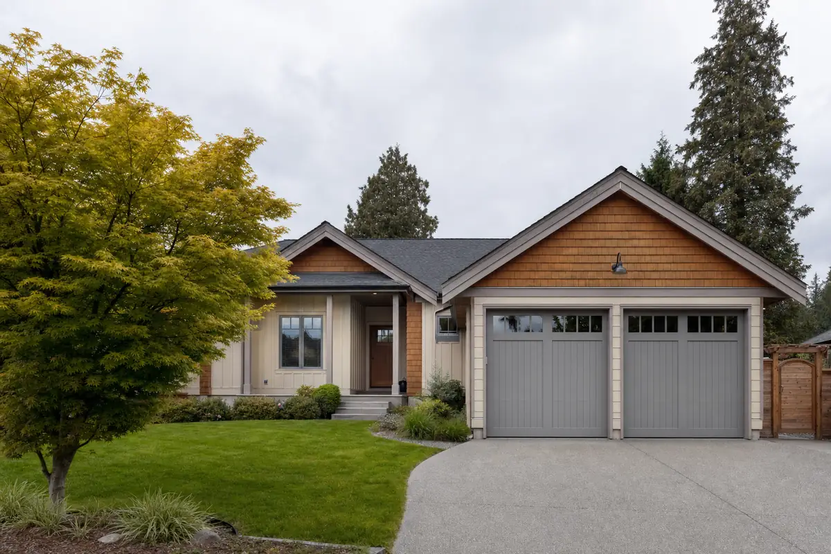 A warm grey grooved-panel garage door on a tidy modest home
