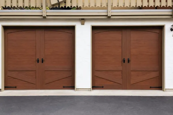 Beautiful carriage style steel garage doors by Clopay, Canyon Ridge Edition in Ultra-Grain Walnut faux finish, with Keyhole handles and spea