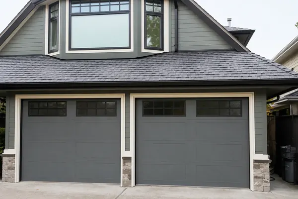 Clopay Gallery Doors nicely painted to match the home, and create an up to date look. In addition, the home owners painted the grilles black