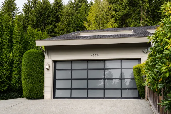 Beautiful glass garage door by Clopay with frosted glass and a black anodized frame.