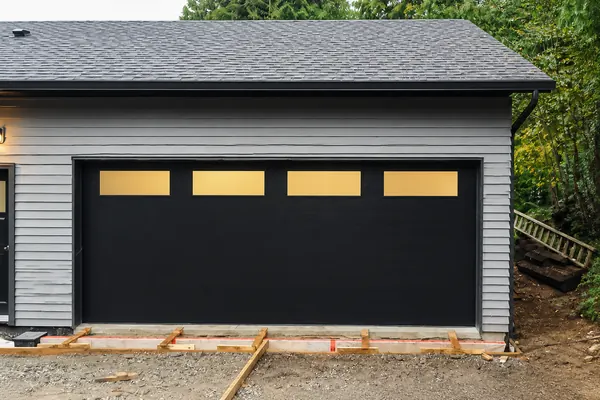 Black flush garage door with custom frosted windows by Clopay.