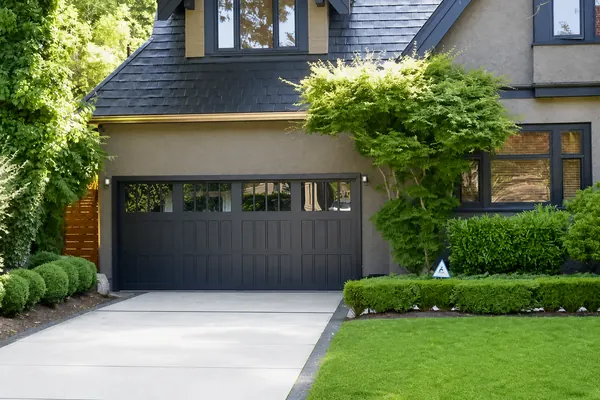 Semi-custom wood garage door by Clopay, painted black by the owner to match the trim. A popular trend in Vancouver to update some of the bea